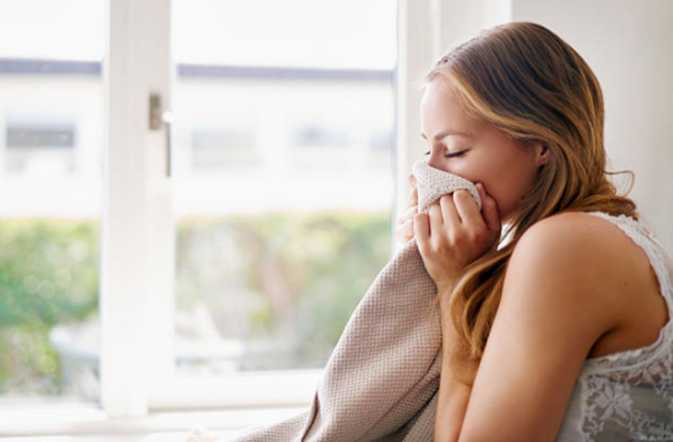 woman smelling freshly laundered clothes.